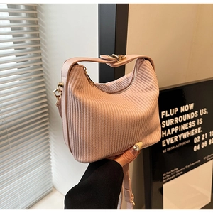 Gros plan du sac à main plissé rose avec fermoir en métal doré et texture élégante
