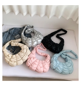 Close-up of pleated crescent bags in silver, black, beige, pink, and light blue colors