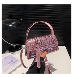 Detail view of pink metallic crossbody bag with textured mirror surface and silver hardware