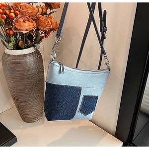 Detail der Denim-Patchwork-Umhängetasche mit Vordertasche und verstellbarem Gurt