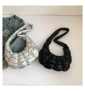 Detailed view of black and silver pleated cloud bags with quilted texture and PU leather
