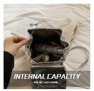 Silver metallic backpack showing interior capacity with drawstring and daily essentials