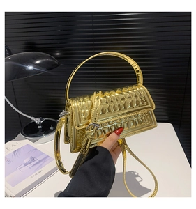 Detail of gold metallic mini handbag featuring a unique rectangular embossed texture