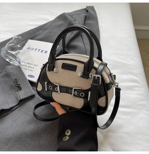 Close-up of retro contrast bowling bag featuring cream fabric and black leather trim