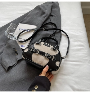 Detail of vintage contrast tote bag with leather straps and canvas on a gray blazer