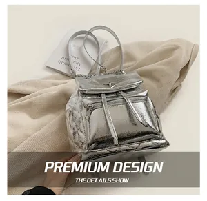 Detailed view of silver quilted backpack featuring metallic finish and chain straps