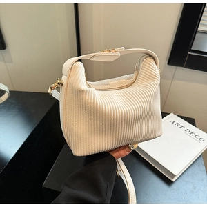 Vue détaillée du tissu en velours côtelé blanc plissé et ferrures dorées du sac à main