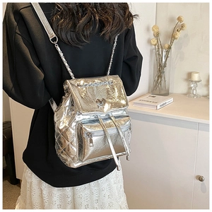 Detail of silver quilted backpack with heart-shaped twist lock and chain straps