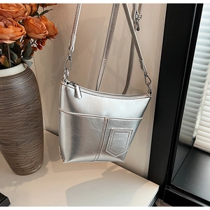 Detail der silbernen Metallic-Lederumhängetasche mit geometrischer Tasche und Riemen