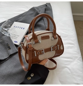 Detail of vintage boston bag with brown leather contrast and canvas texture on grey suit