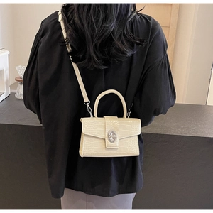 Rear view of a model wearing the cream crocodile pattern crossbody bag with silver hardware
