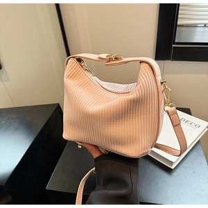 Détail du sac à main plissé en velours rose clair avec ferrures dorées et bandoulière