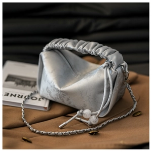 Détails du sac à main argenté texturé avec poignée plissée et bandoulière chaîne