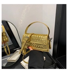 Close-up of golden quilted handbag showing metallic texture and adjustable strap