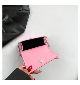 Pink mini crossbody bag featuring a black lining and magnetic buckle with silver hardware
