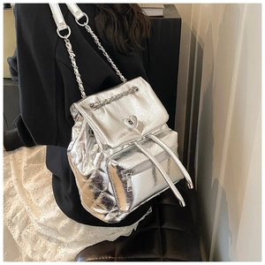 Detailed view of silver metallic quilted backpack with heart-shaped twist lock closure