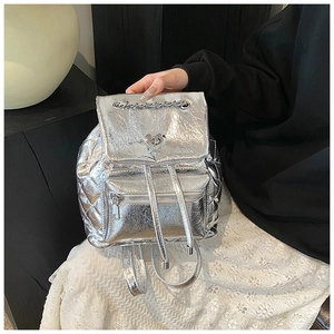 Detail of silver textured PU leather backpack featuring heart lock and chain handle