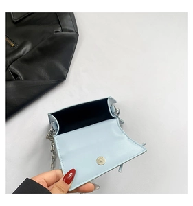 Detail view of mini blue bag interior with magnetic silver clasp and black lining