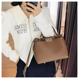 Brown lychee leather tote bag shown as a crossbody in a mirror selfie OOTD