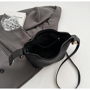 Vue détaillée du sac bandoulière noir plissé avec fermeture dorée et poche intérieure