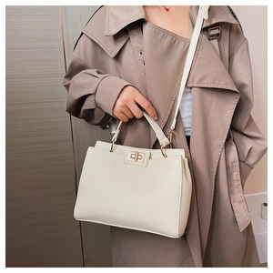 Detail of cream white textured leather tote bag with elegant gold twist-lock closure