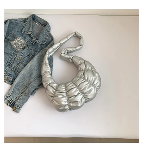 Detail of silver pleated crescent bag with metallic cloud texture and wide shoulder strap