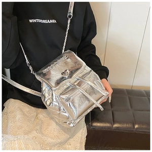 Detail of silver metallic backpack with heart lock and chain strap on shoulder