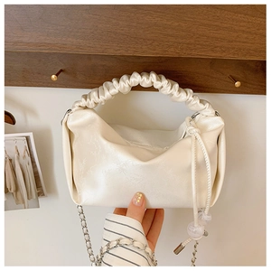 Détail du sac à main plissé crème avec texture jacquard florale et bandoulière chaîne