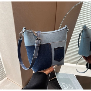 Detail einer Patchwork-Jeans-Beuteltasche mit gelben Nähten und verstellbarem Schultergurt