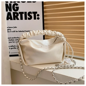 Vue détaillée du sac plissé crème avec cuir texturé et bandoulière en chaîne argentée