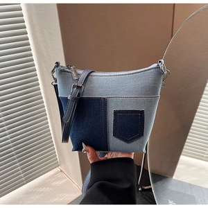 Detail der Denim-Patchwork-Umhängetasche mit orangefarbenen Nähten und Minitaschen-Design