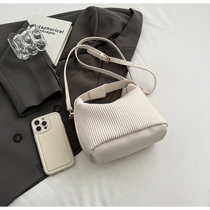 Détail du sac à main plissé blanc cassé avec cuir litchi et finitions dorées chic