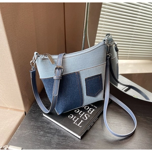 Detail der blauen Denim-Beuteltasche mit Patchwork-Design und verstellbarem Trageriemen