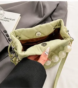 Détail du sac seau matelassé vert clair avec perles et fermeture magnétique argentée