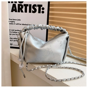 Vue détaillée du sac à main plissé argenté avec motifs de feuilles et chaîne