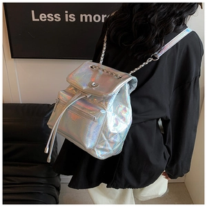 Silver laser quilted backpack with heart buckle and chain strap on female model