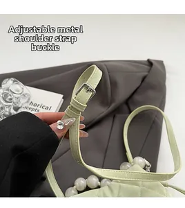 Détail du sac seau matelassé vert avec boucle réglable et bandoulière perles