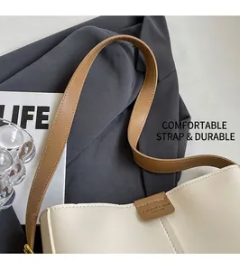 Dettaglio della borsa a tracolla in pelle con cinturino marrone e logo della moda