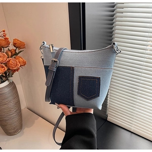 Detailansicht der Denim-Patchwork-Schultertasche mit orangefarbenen Nähten und Zipper