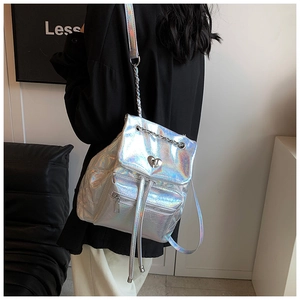 Close-up of holographic silver backpack with heart buckle and chain strap detail
