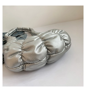 Detail view of metallic silver pleated cloud bag with soft texture and high shine finish