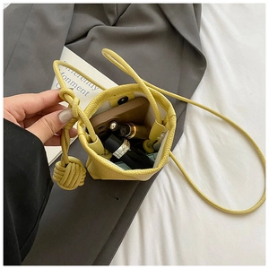 Internal view of yellow pebble leather mini crossbody bag showing phone and lipstick storage