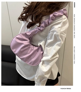 Detail of lavender ruched crescent underarm bag showing soft pleated PU leather texture