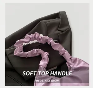 Detail view of the light purple handbag featuring a unique pleated cloud-style handle design