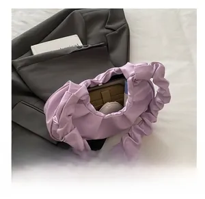 Internal capacity detail of lavender pleated cloud bag showing wallet and makeup items