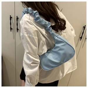 Detail of light blue crescent cloud bag with scrunchie strap and soft pleated texture