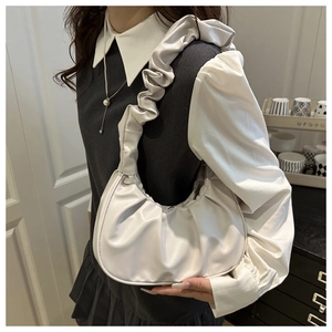 Detailed view of the pleated white crescent bag with a soft ruched shoulder strap