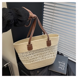 Détail du sac cabas en paille tissé main avec motif ajouré et anses en cuir marron