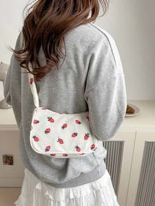 White corduroy strawberry tote bag shown from a stylish back view with casual outfit