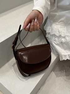 Elegant dark brown saddle bag in glossy faux leather with adjustable strap for women